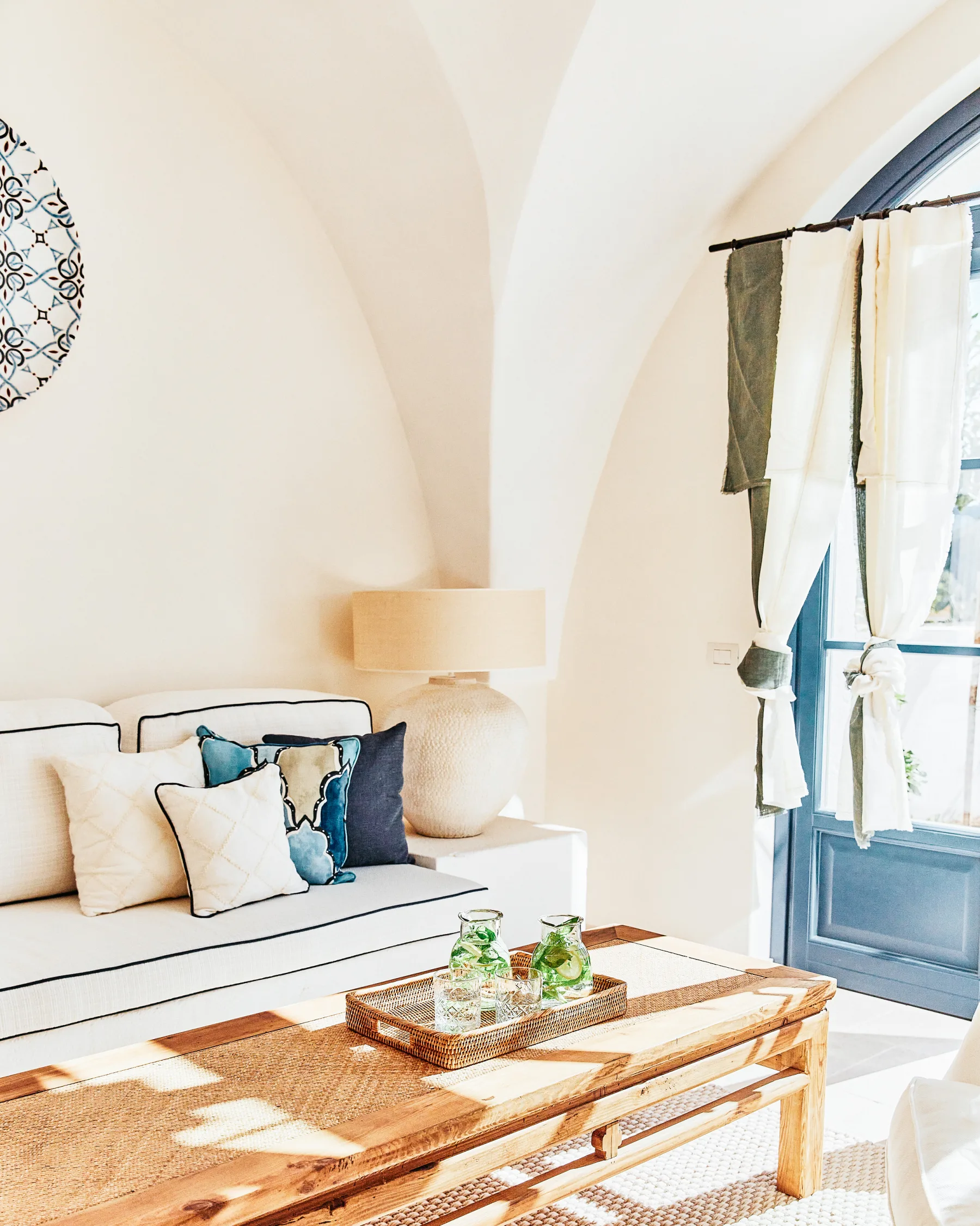 Vaulted living room at Masseria Calderisi with blue shuttered doors and afternoon light, an intimate Puglian boutique retreat