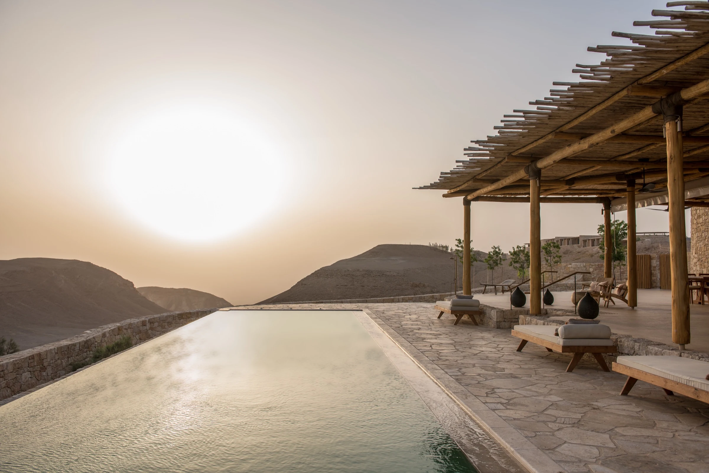 Infinity pool catching late sun at Six Senses Shaharut, framed by the Negev landscape